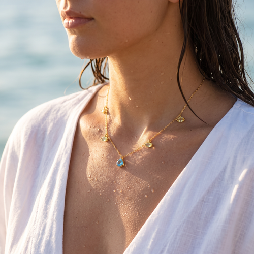 Mujer llevando el collar ovalado aguamarina en la playa